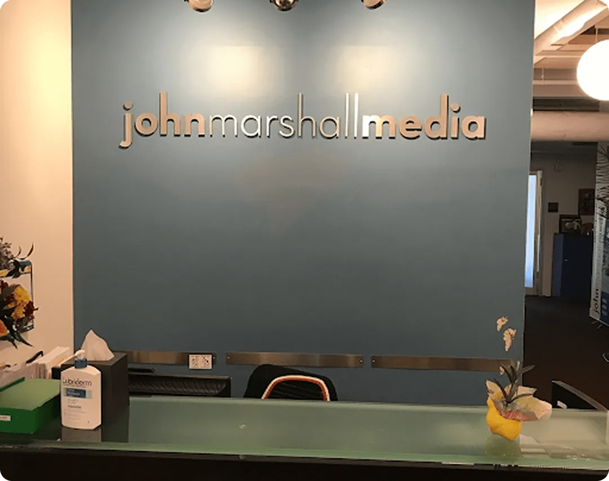 Reception desk with company logo on wall.
