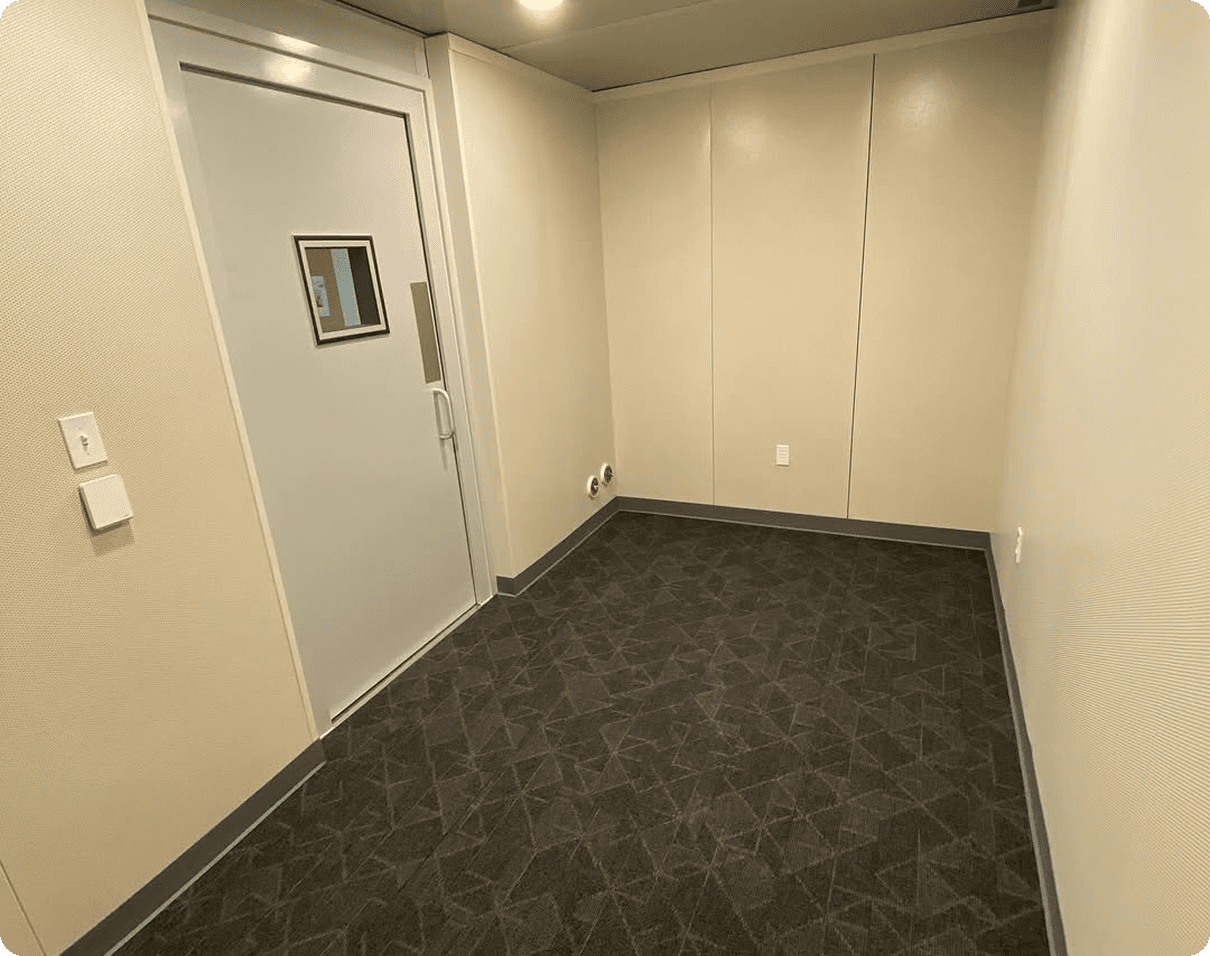 Room with a door and a window in it, illuminated by lights on the ceiling