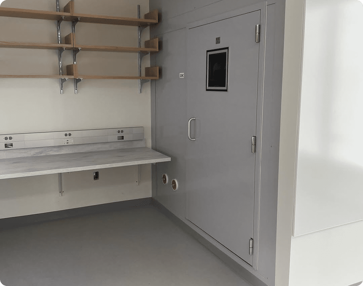 Laboratory with a white wall and a door, as well as a platform with racks and a sink