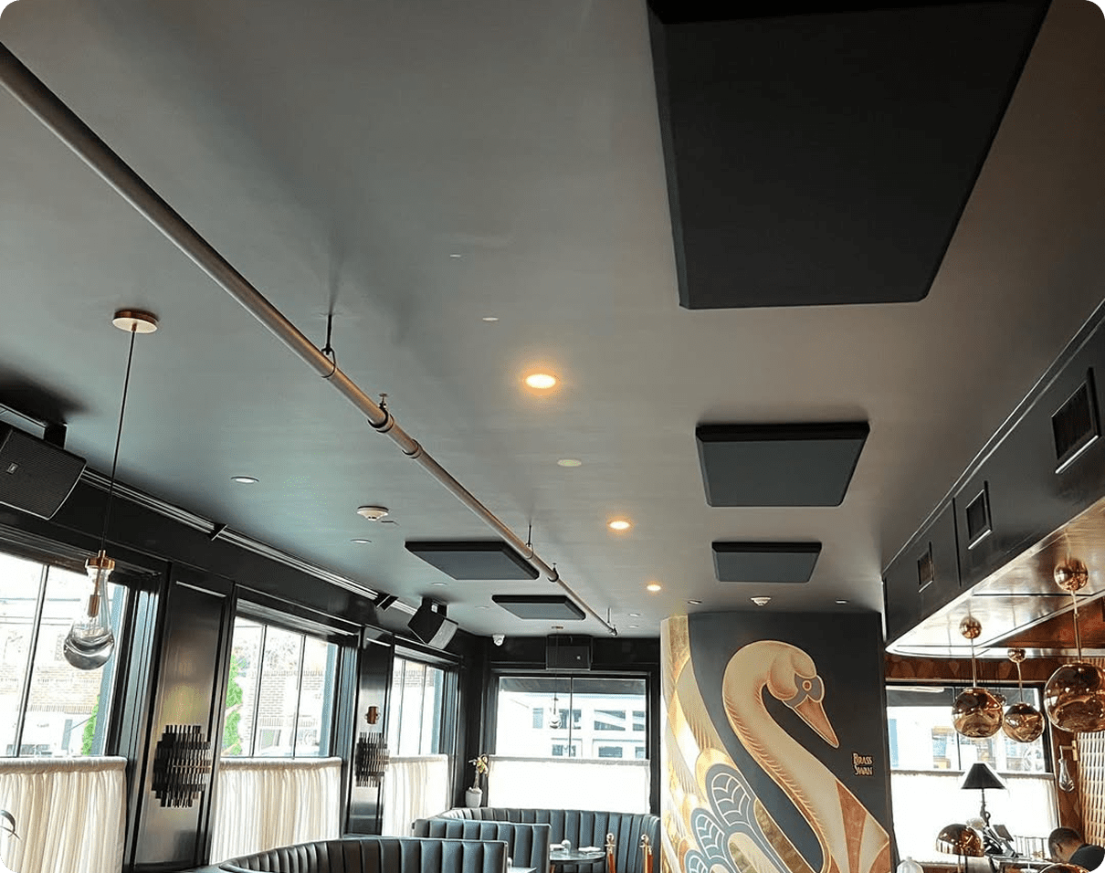 Restaurant with black and white furniture, including sofas, tables, chairs, and a painting on the wall