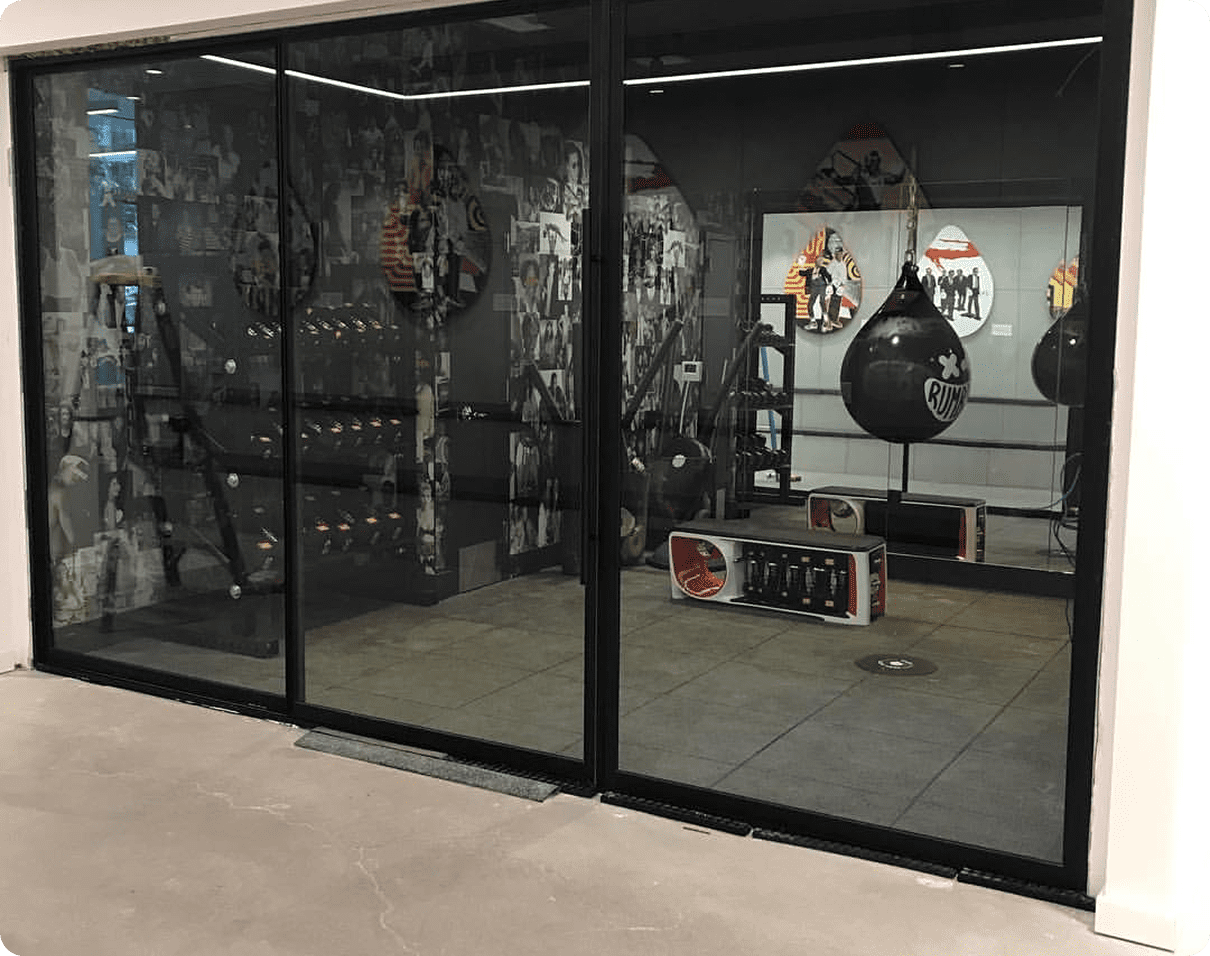 Store front with a glass door and a punching bag in the middle of it