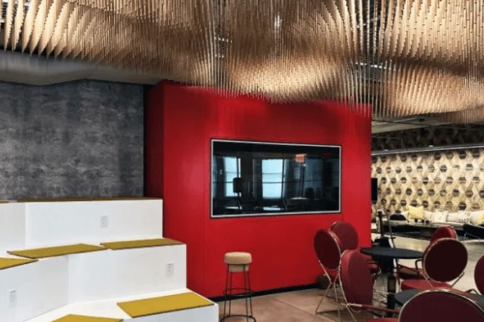 Screenshot: Room with red chairs and tables arranged in front of a red wall